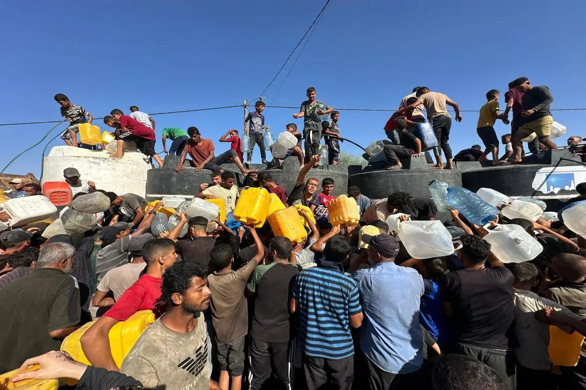 Palestinos sedentos fazem fila para receber água limpa distribuída por tanques móveis em Nuseirat, Gaza, em 18 de junho de 2024 [Mohammed Asad/Monitor do Oriente Médio]
