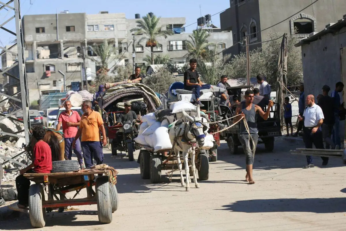 Palestinos, carregando seus pertences, estão a caminho de fugir para áreas mais seguras após o aviso do exército israelense para a evacuação das áreas de Abu Areef e Al-Mazra em Deir al-Balah, Gaza, em 21 de agosto de 2024 [Ashraf Amra/Agência Anadolu]
