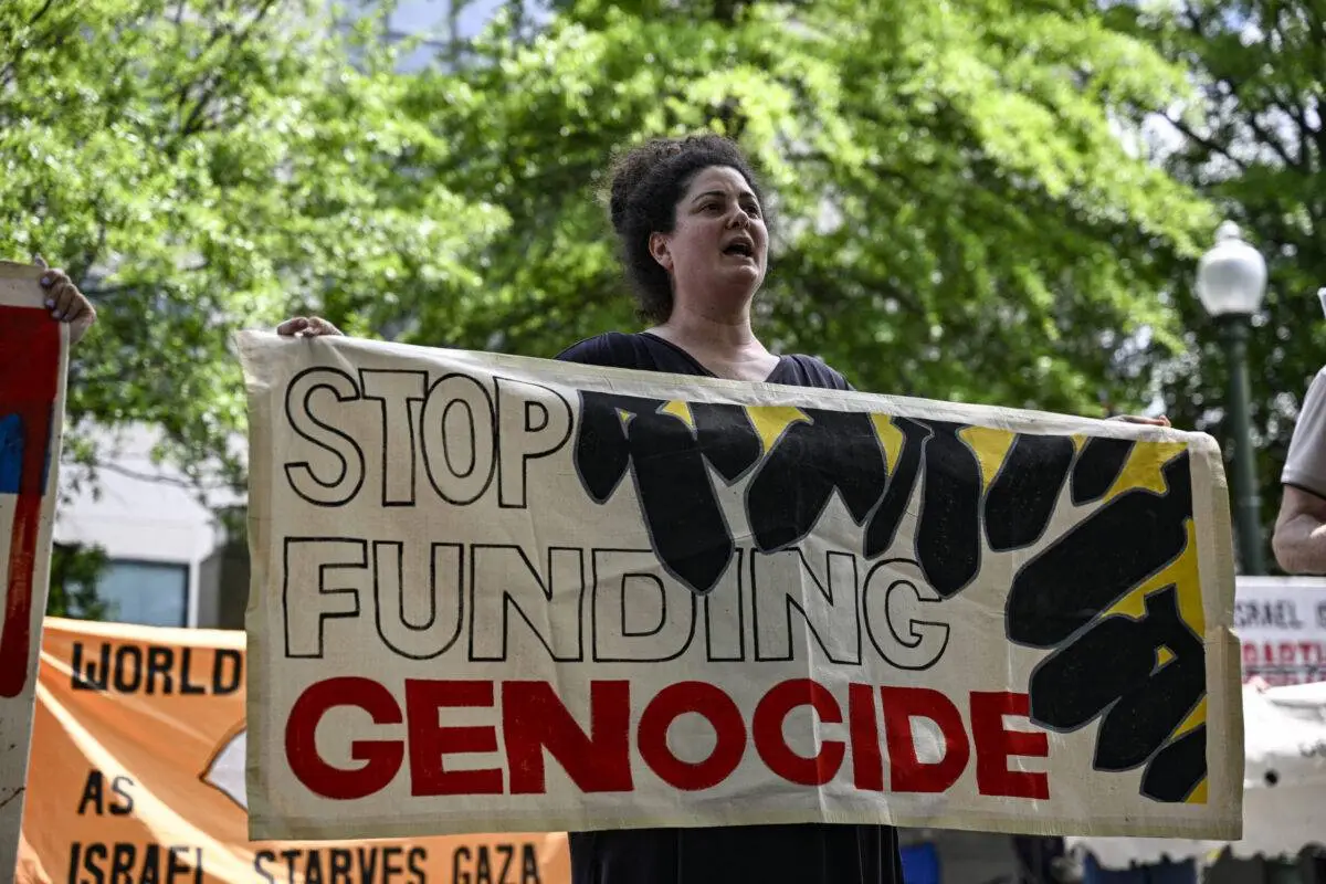 Mulher segura uma faixa com os dizeres “parem de financiar o genocídio” durante manifestação de solidariedade aos palestinos em frente à Embaixada de Israel em Washington DC, Estados Unidos, em 28 de maio de 2024 [Celal Gunes/Anadolu via Getty Images]
