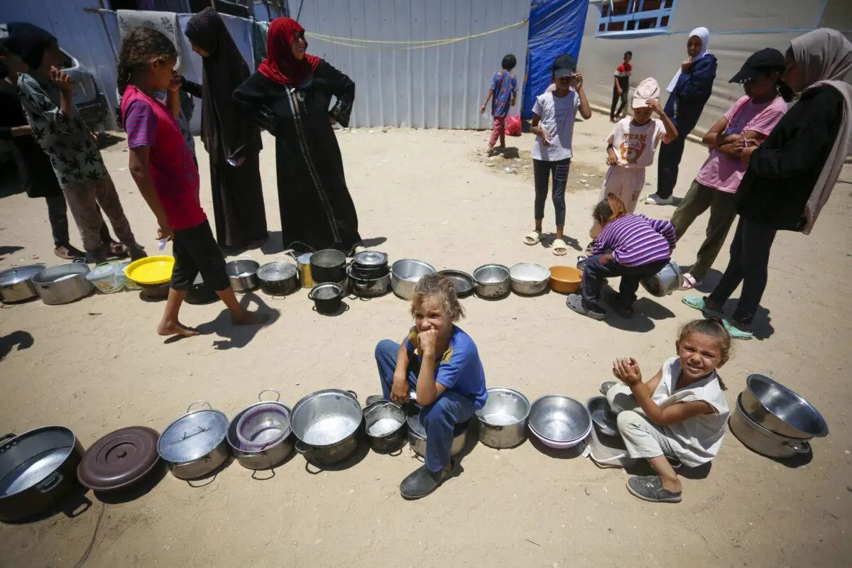Crianças palestinas recebem auxílio em Deir al-Balah, Gaza, em 30 de junho de 2024 [Ashraf Amra/Anadolu via Getty Images]
