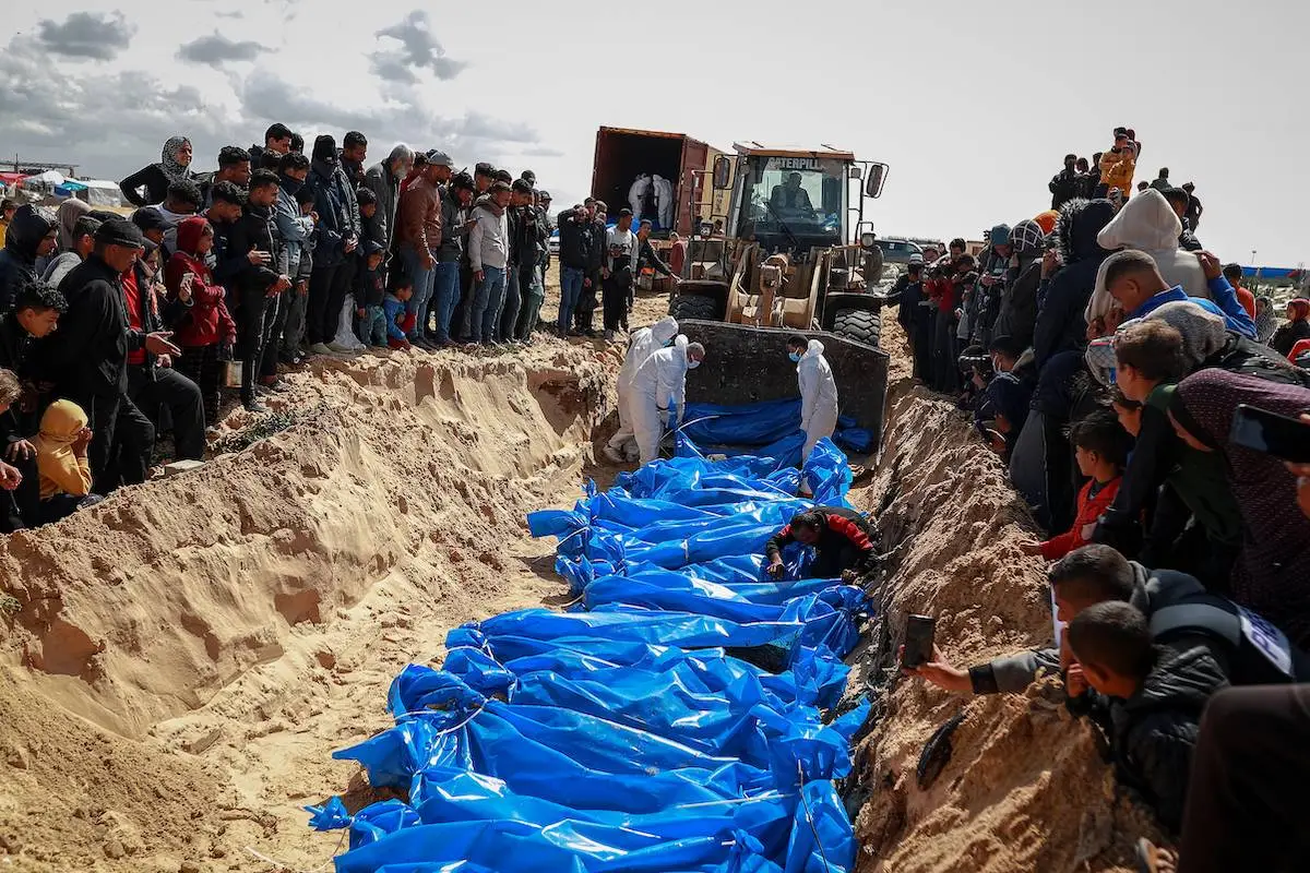 Corpos de 47 palestinos, que foram mortos nos intensos ataques de Israel a Gaza e cujos corpos foram retidos, são enterrados em uma vala comum depois de serem retirados do portão de fronteira Kerem Abu Salim em Rafah, Gaza, em 7 de março de 2024 [Jehad Alshrafi/Agência Anadolu]
