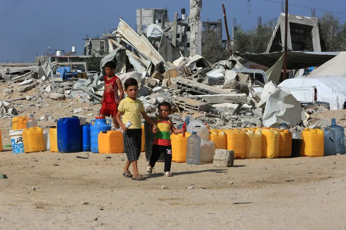 Crianças palestinas reúnem galões de água em meio aos bombardeios de Israel, em Khan Younis, Gaza, em 8 de setembro de 2024 [Abed Rahim Khatib/Agência Anadolu]
