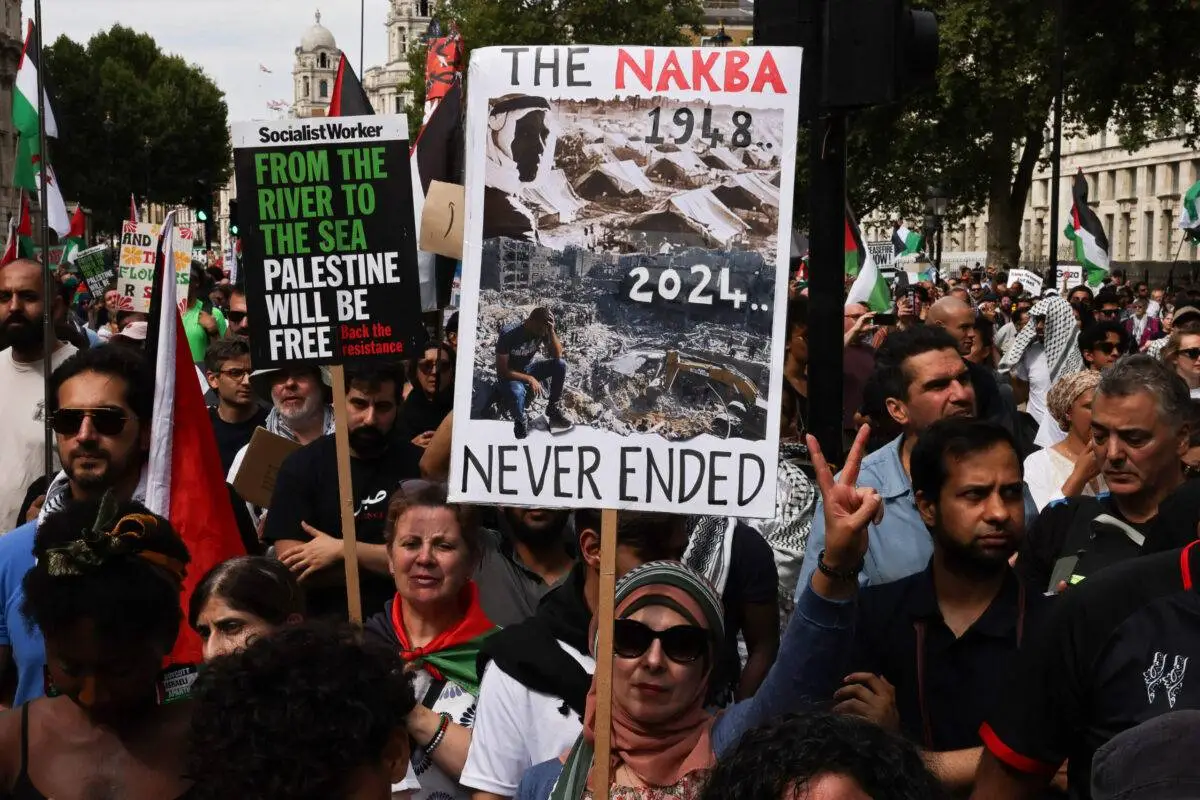 Uma pessoa segura um cartaz com os dizeres “A Nakba nunca terminou” em Londres durante a “Marcha Nacional por Gaza” em 3 de agosto de 2024 [Carlos Jasso/ AFP via Getty Images] 
