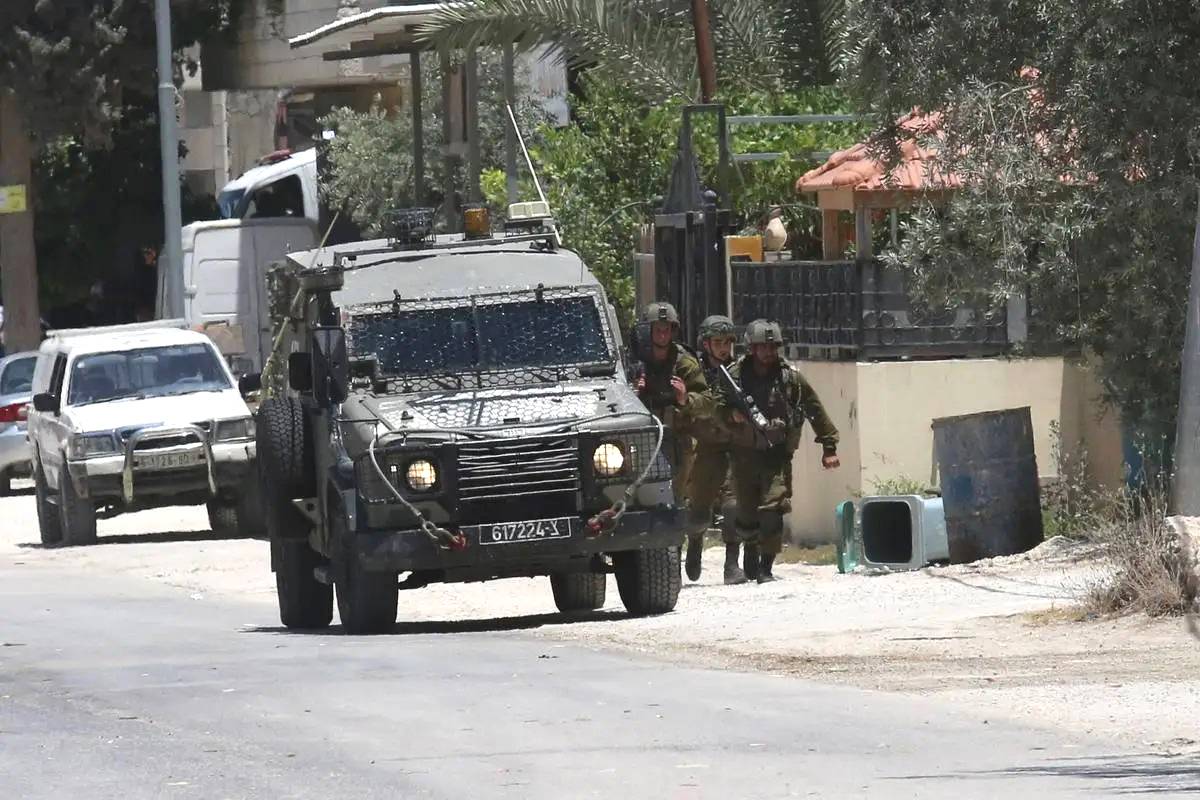 Soldados israelenses patrulham uma rua para procurar palestinos procurados na vila de Urif em Nablus, Cisjordânia em 29 de junho de 2023 [Nedal Eshtayah/ Agência Anadolu]
