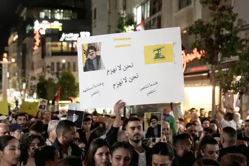 Pessoas, segurando faixas e bandeiras, se reúnem para protestar contra Israel após o assassinato de Nasrallah em 28 de setembro de 2024 em Ramallah, Cisjordânia. [Issam Rimawi - Agência Anadolu]