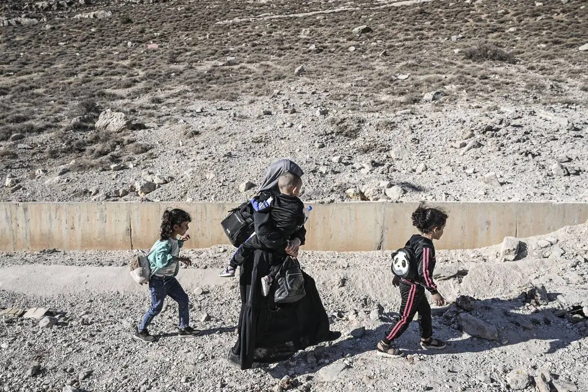 Sírios e libaneses que vivem no Líbano cruzam para o lado da Síria com seus pertences que poderiam levar com eles na travessia da fronteira de Masnaa após os ataques israelenses em Massna, Líbano, em 4 de outubro de 2024 [Murat Şengül/ Agência Anadolu]
