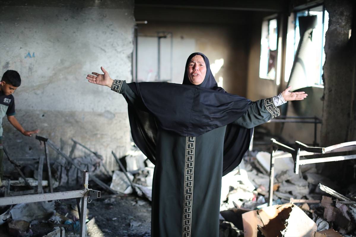 Moradores inspecionam os danos após ataques israelenses à Escola Ard al-Mufti da Agência das Nações Unidas de Assistência e Obras para Refugiados da Palestina (UNRWA) no campo de refugiados de Nuseirat, na Cidade de Gaza, Gaza, em 14 de outubro de 2024  [Hassan Jedi
/Agência Anadolu]