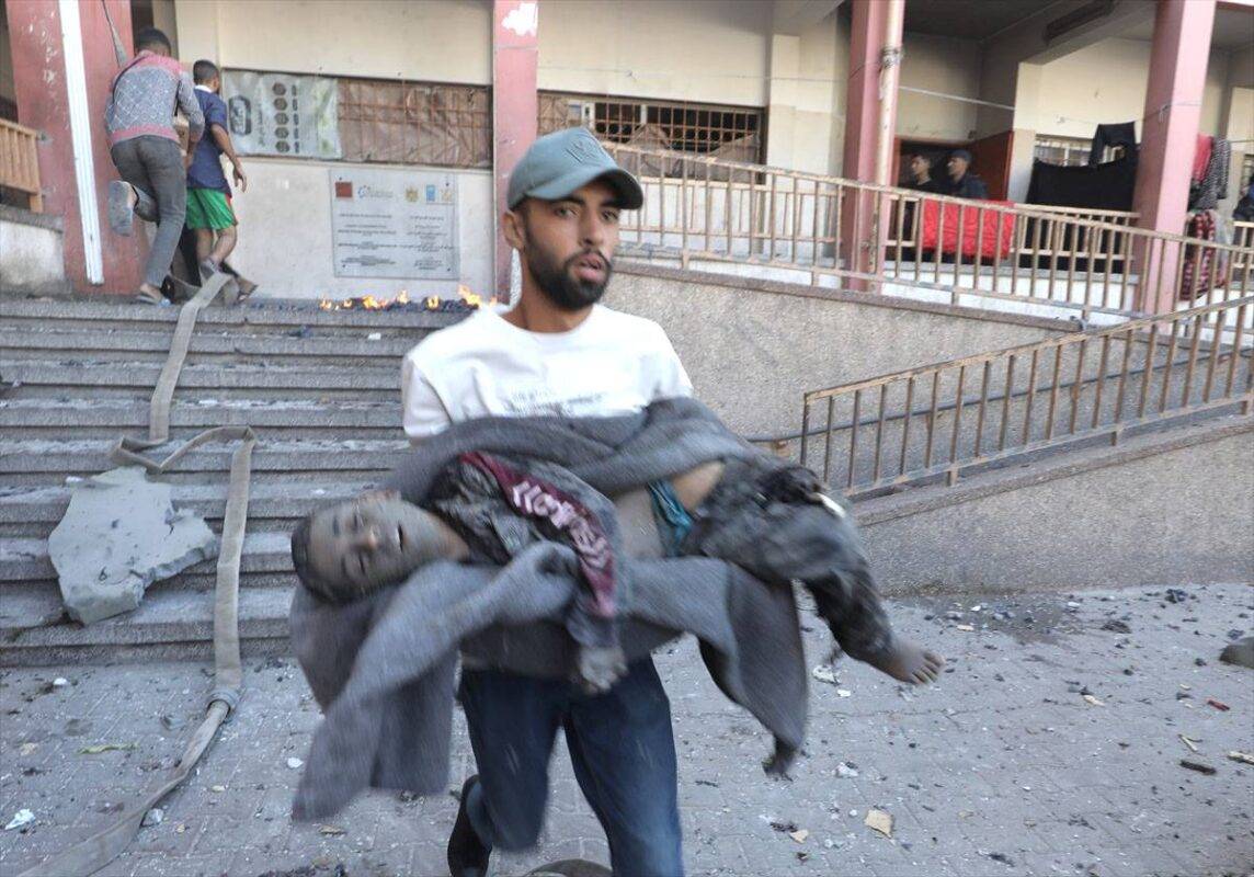 Palestinos resgatam crianças mortas e feridas por bombardeio israelense a uma escola convertida em abrigo no campo de refugiados de Nuseirat, em Deir al-Balah, Gaza, em 24 de outubro de 2024 [Moiz Salhi/Agência Anadolu]
