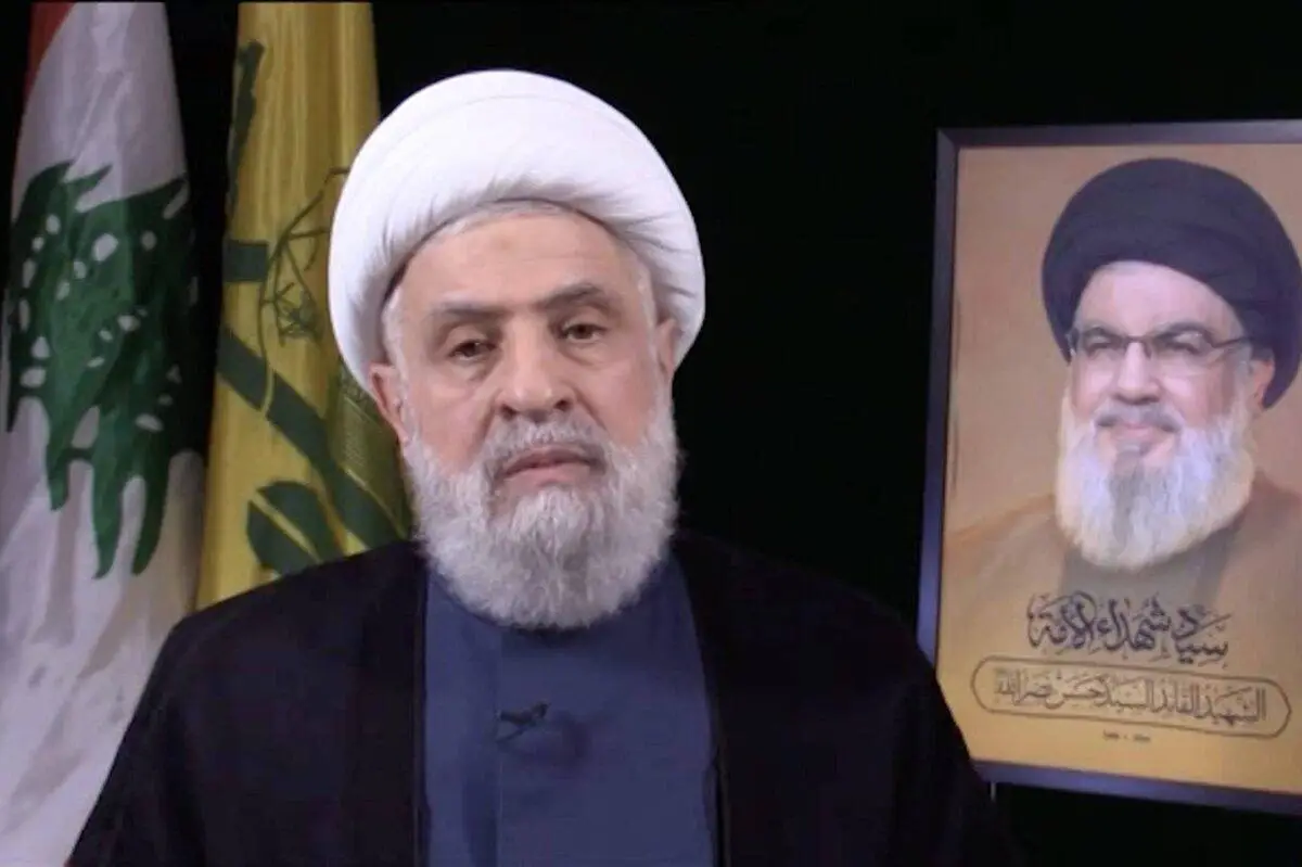 Naim Qassem, novo secretário-geral do grupo Hezbollah, ao lado de um retrato de seu antecessor, Hassan Nasrallah, durante pronunciamento em vídeo realizado na capital libanesa Beirute, em 30 de outubro de 2024 [Stringer/Agência Anadolu]
