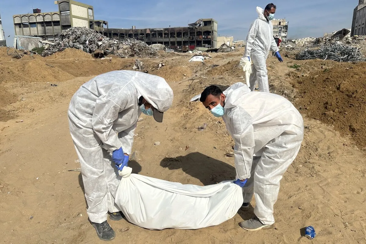 Equipes, vestindo trajes de proteção, exumam corpos de palestinos, mortos durante ataques israelenses em Sheikh Zayed no norte de Gaza, Gaza em 02 de fevereiro de 2025. [Hasan N. H. Alzaanin/ Agência Anadolu]