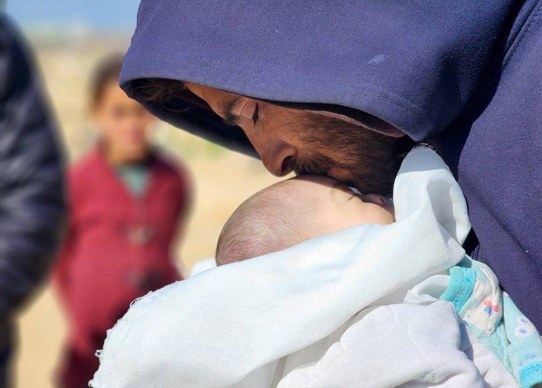 Familiares de Shem al-Shambari, bebê de dois meses que morreu de frio em sua tenda devido ao cerco israelense, carregam o corpo para sepultamento, em Khan Yunis, Gaza, em 25 de fevereiro de 2025 [Hani Alshaer/Agência Anadolu]