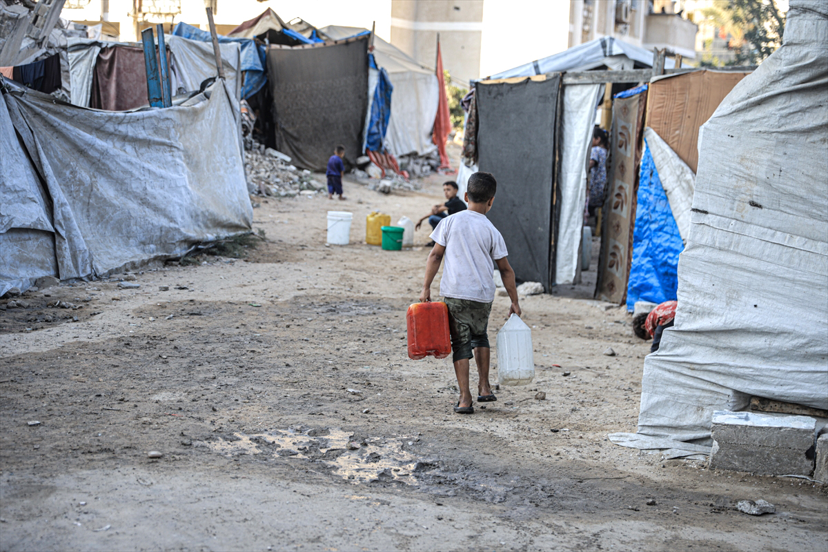 Crianças palestinas tentam suprir suas necessidades diárias de água com água limpa, distribuída por caminhões-tanque, enquanto os ataques israelenses agravam a crise humanitária no bairro de en-Nasr, na Cidade de Gaza, em 25 de agosto de 2025. [Ahmed Jihad Ibrahim Al-Arini/Agência Anadolu]
