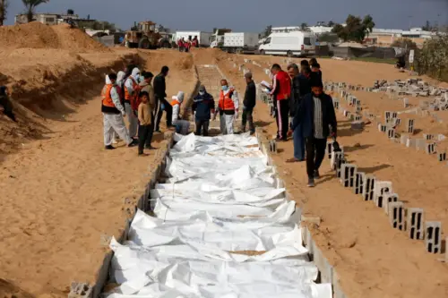 Equipes da Defesa Civil e da Cruz Vermelha são vistas durante o enterro de 30 palestinos cujos corpos foram entregues por Israel sob o acordo de cessar-fogo, em Deir al-Balah, Gaza, em 14 de novembro de 2025. [Mohammed Nassar/ Agência Anadolu]