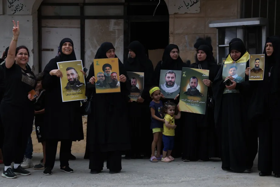 Um grupo de manifestantes, portando faixas, cartazes e fotos de membros do Hezbollah mortos pelo exército israelense na cidade, juntamente com bandeiras libanesas, se reúne para realizar uma manifestação carregando bandeiras do Hezbollah após o embaixador dos EUA em Ancara e enviado especial para a Síria, Tom Barrack, cancelar sua visita planejada a Khiam, cidade na fronteira com Israel, e à cidade costeira de Tiro, no sul do Líbano, em Khiam, Líbano, em 27 de agosto de 2025. [Ramiz Dallah/ Agência Anadolu]