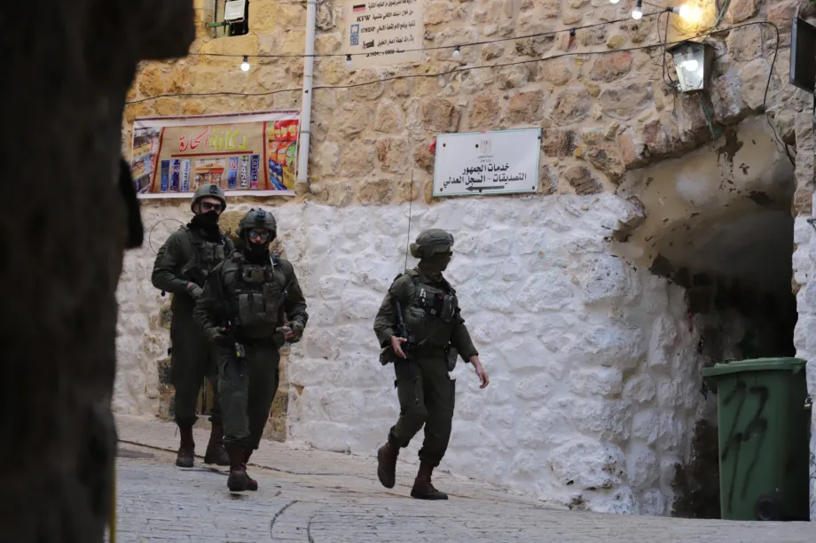 Soldados israelenses bloqueiam estradas e restringem a circulação de palestinos enquanto colonos israelenses ilegais, sob a proteção das forças israelenses, realizam uma incursão na Cidade Velha de Hebron, no sul da Cisjordânia, em 20 de dezembro de 2025. [Amer Shallodi/ Agência Anadolu]
