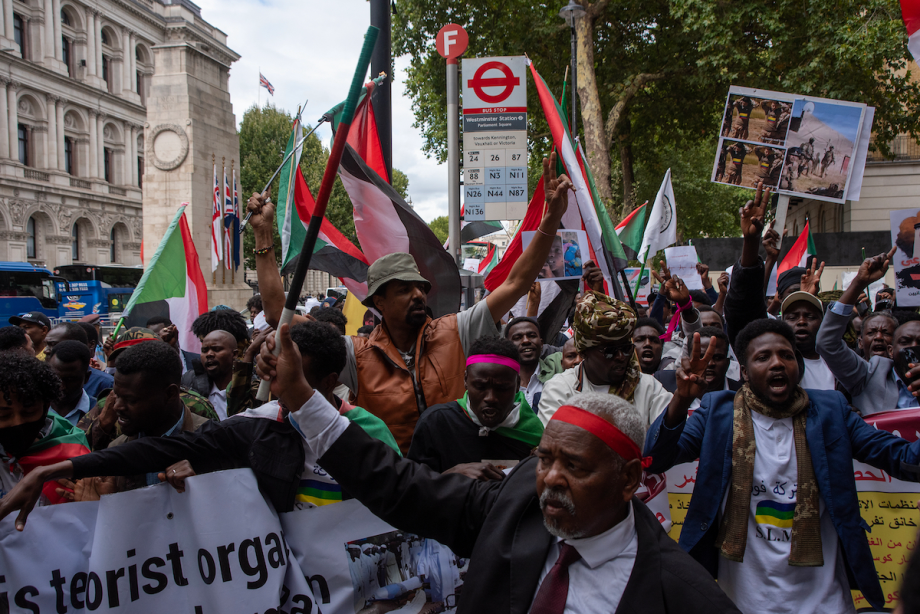Manifestantes agitam bandeiras e gritam slogans durante o protesto. Centenas de habitantes de Darfur se reuniram em Whitehall para exigir paz em Darfur, Sudão, em 30 de agosto de 2025 [Krisztian Elek/SOPA Images/LightRocket via Getty Images]