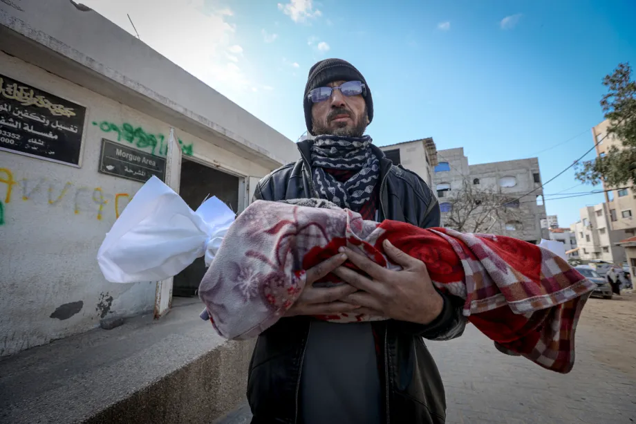 Homem vela bebê palestino de três meses, morto por hipotermia, em Gaza sitiada, em 20 de janeiro de 2026 [Hamza Z. H. Qraiqea/Agência Anadolu]