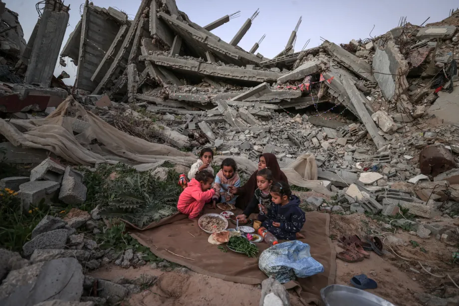Uma família palestina que vive no bairro de Tel al-Hawa quebra o jejum do Ramadã pela primeira vez perto dos escombros de sua casa, destruída após os ataques israelenses, em 18 de fevereiro de 2026, na Cidade de Gaza, Gaza. [Ali Jadallah - Agência Anadolu]