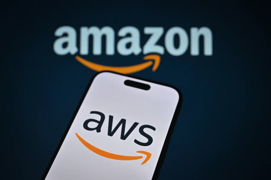 Logotipo da Amazon é exibido na tela de um celular em frente aos ícones da empresa em Ancara, Turquia, em 20 de outubro de 2025. [Hakan Nural - Agência Anadolu]