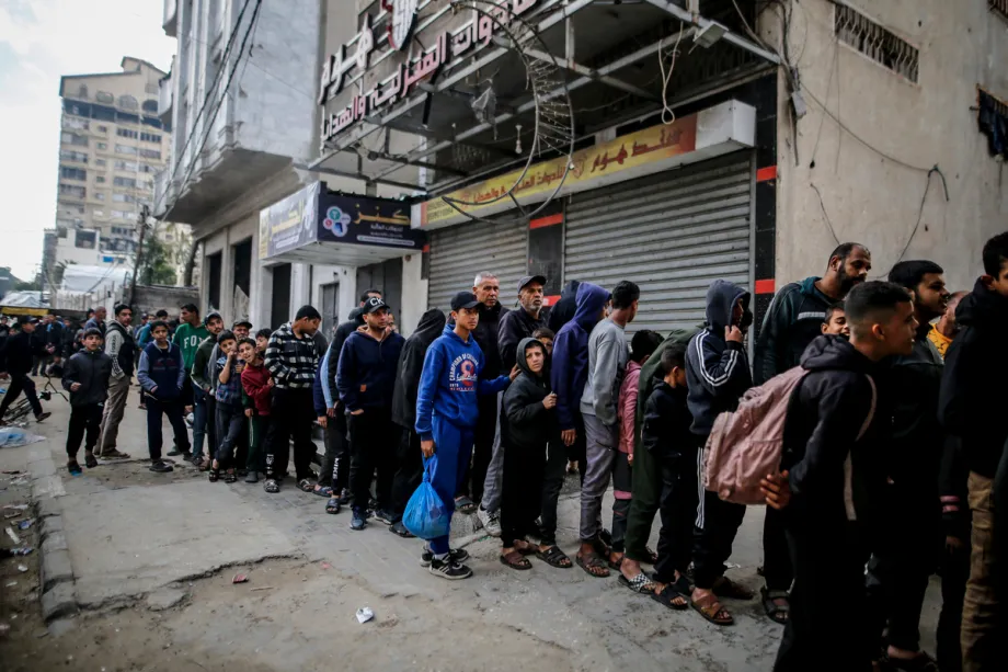 Palestinos, incluindo crianças, aguardam em fila em frente a uma padaria para comprar pão no bairro de Rimal, na Cidade de Gaza, Palestina, em 8 de abril de 2026. [Saeed M. M. T. Jaras - Agência Anadolu]