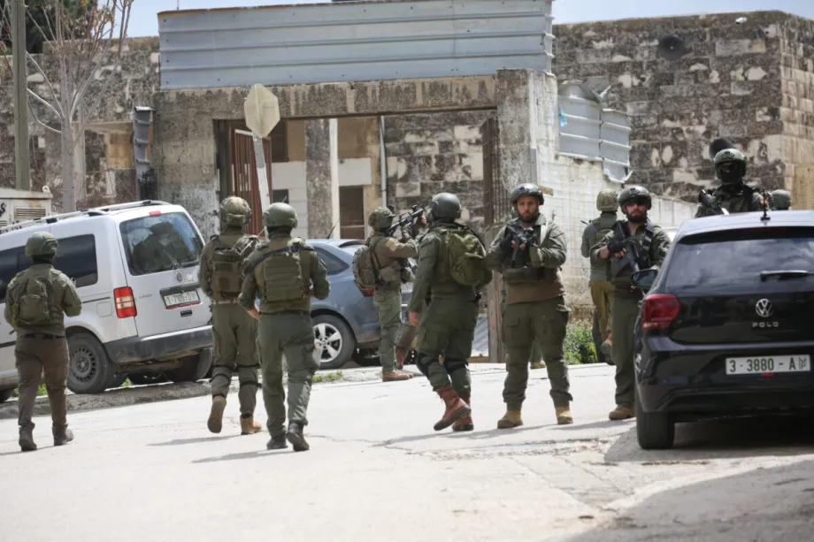 Soldados israelenses em pé em uma rua durante uma incursão do exército israelense na cidade de Nablus, no norte da Cisjordânia, Palestina, em 12 de abril de 2026. [Nedal Eshtayah - Agência Anadolu]