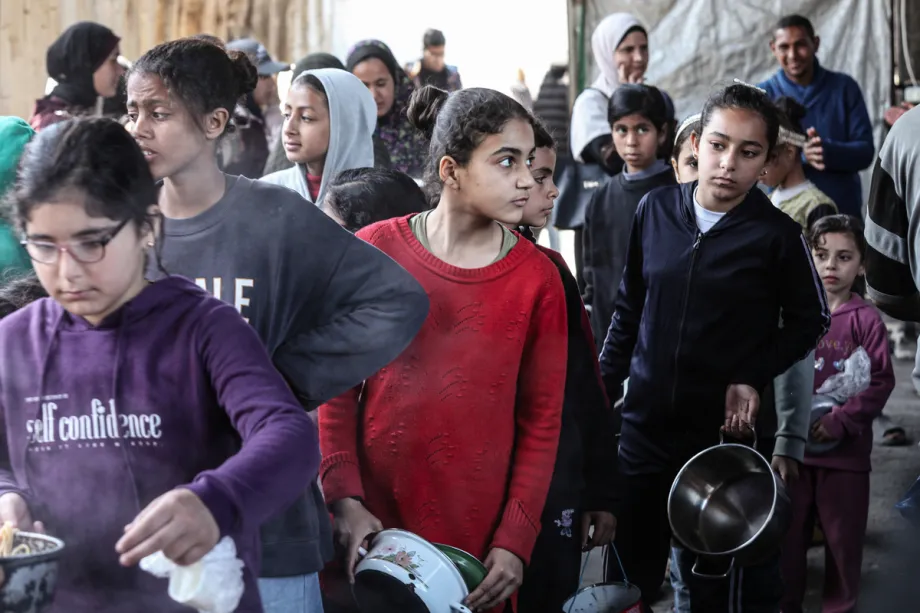 Uma organização beneficente distribui refeições quentes para palestinos no campo de Nuseirat, enquanto o bloqueio israelense e as restrições à entrada de ajuda continuam, em Deir al Balah, Palestina, em 13 de abril de 2026. [Moiz Salhi - Agência Anadolu]