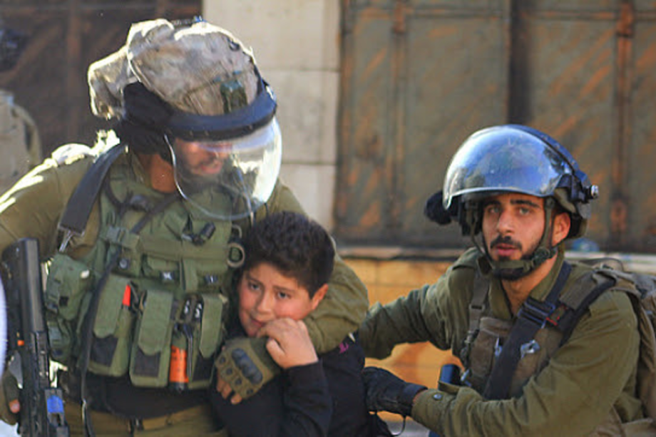 Soldados israelenses detêm uma criança palestina em Hebron, Cisjordânia