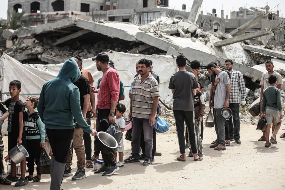 Palestinos deslocados, incluindo muitas crianças, aguardam em longas filas para receber refeições quentes distribuídas por uma organização beneficente no campo de refugiados de Bureijj, na Cidade de Gaza, Gaza, Palestina, em 18 de maio de 2026. [Moiz Salhi – Agência Anadolu]