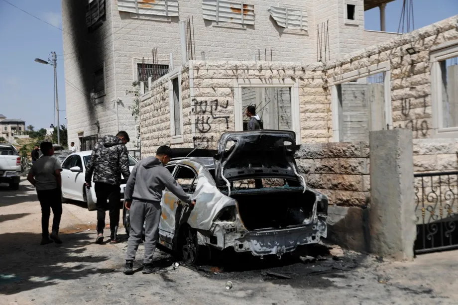 Palestinos inspecionam a extensão da destruição após forças israelenses incendiarem dois veículos de propriedade palestina na vila de Halhul, Hebron, Cisjordânia, Palestina, em 20 de maio de 2026. [Mamoun Wazwaz – Agência Anadolu]