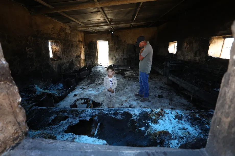 Um homem palestino e uma menina estão dentro de uma casa danificada em um ataque realizado por colonos israelenses na comunidade de Khirbet al-Tuba, na região de Masafer Yatta, ao sul de Hebron, na Cisjordânia, Palestina, em 6 de agosto de 2026. [Wisam Hashlamoun – Agência Anadolu]