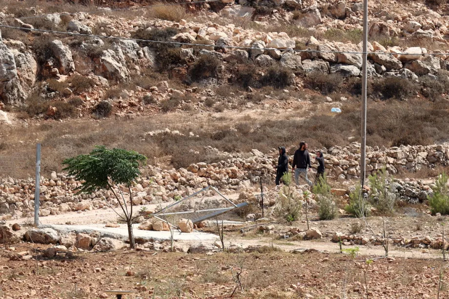 Colonos israelenses são vistos enquanto moradores palestinos permanecem confinados dentro de suas casas na aldeia de Qusra, ao sul de Nablus, na Cisjordânia, em 20 de agosto de 2026, depois que o Exército israelense declarou três propriedades residenciais como uma “zona militar fechada”, após repetidos ataques e bloqueios realizados por colonos israelenses. [Issam Rimawi – Anadolu Agency]