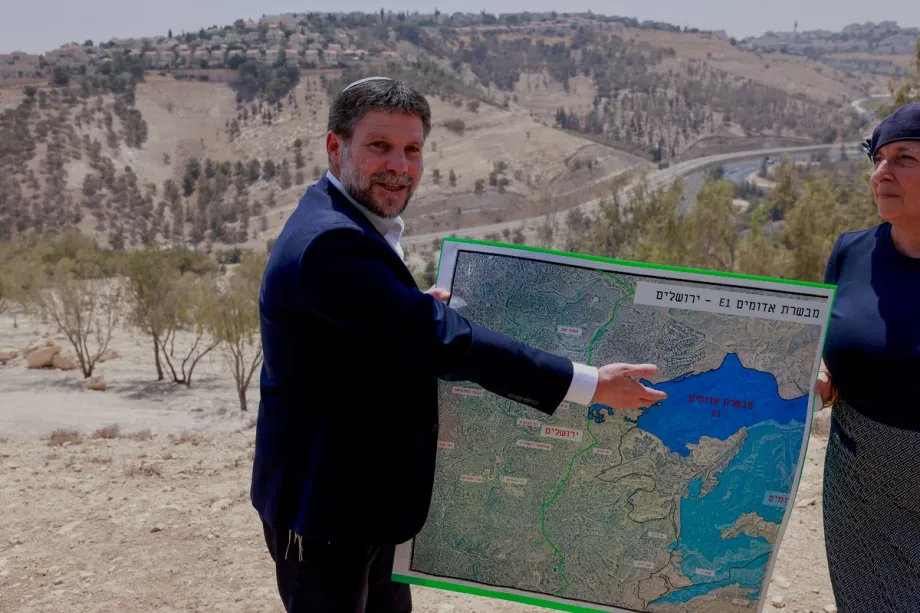 O ministro das Finanças israelense de extrema direita, Bezalel Smotrich, exibe um mapa de uma área próxima ao assentamento de Maale Adumim, um corredor territorial conhecido como E1, nos arredores de Jerusalém, na Cisjordânia ocupada, em 14 de agosto de 2025. [Foto: Menahem Kahana/AFP via Getty Images]